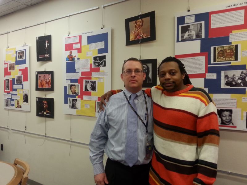 Staff members Desharwn Brown (right) and Daniel Sabol (left) stand in front of library showcase.
