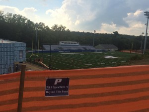 Orange fencing restricting fans from watching games past the point from the hill above Pace Stadium. 