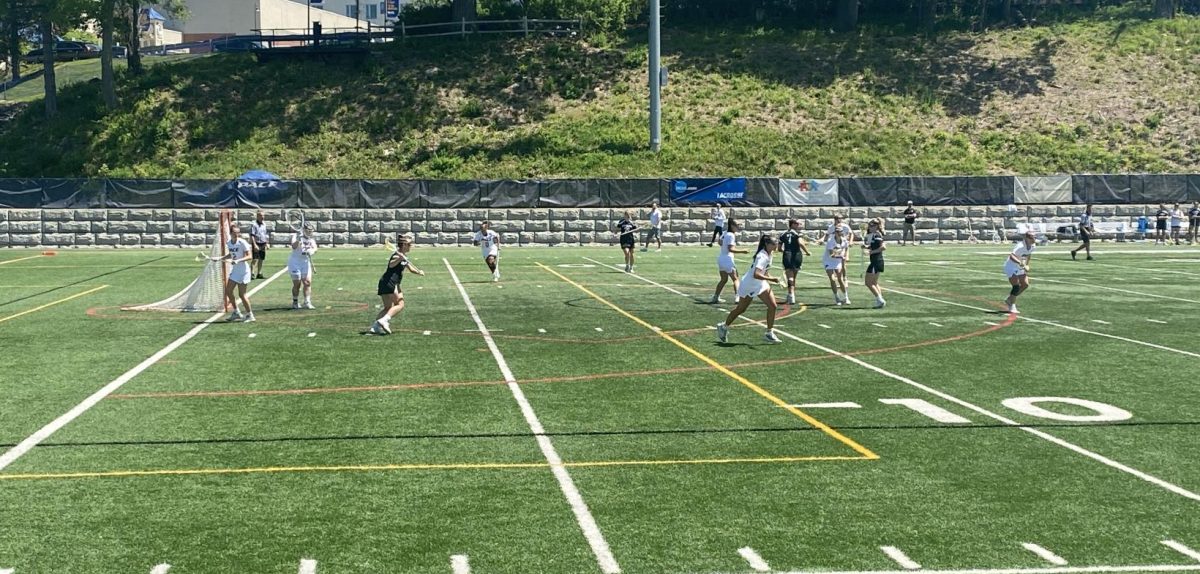 Pace Women's Lacrosse plays defense versus Adelphi University in the 2023 NCAA East Regional Final on May 14, 2023. Note the NCAA banner in the background.
